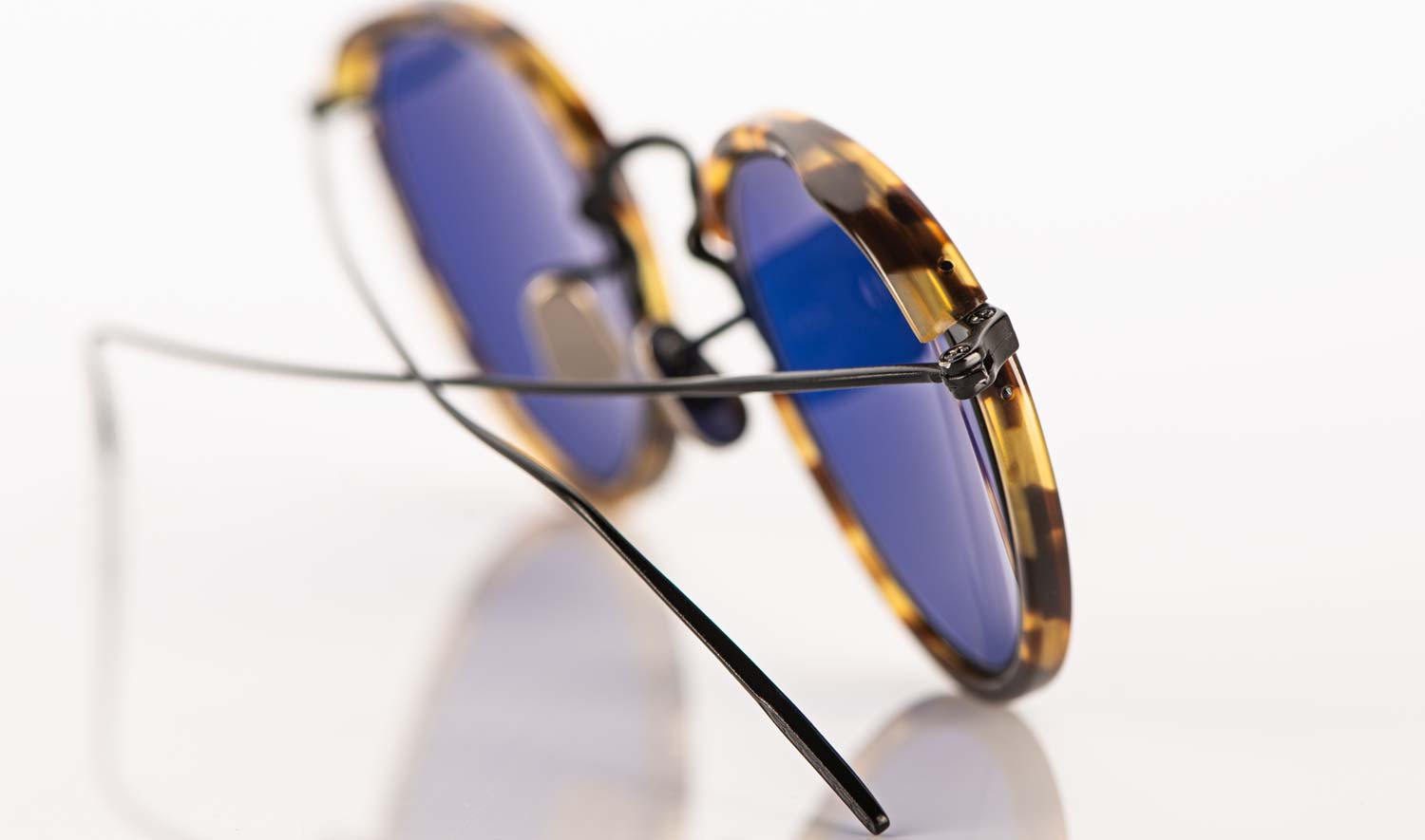 Eyevan – Panto Sonnenbrille aus schwarzem Metall mit tortoise farbigen Acetat und blauen Gläsern - KITSCHENBERG Brillen