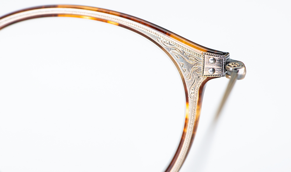 Eyevan – Detail einer ziselierten einlaminierten Metalleinlage in einer runden Acetatbrille - KITSCHENBERG Brillen